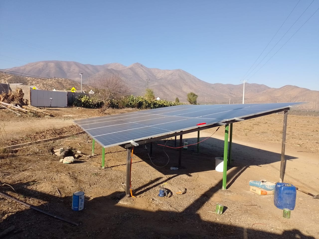 Instalación de paneles solares sobre techo, vista de valle agrícola al fondo